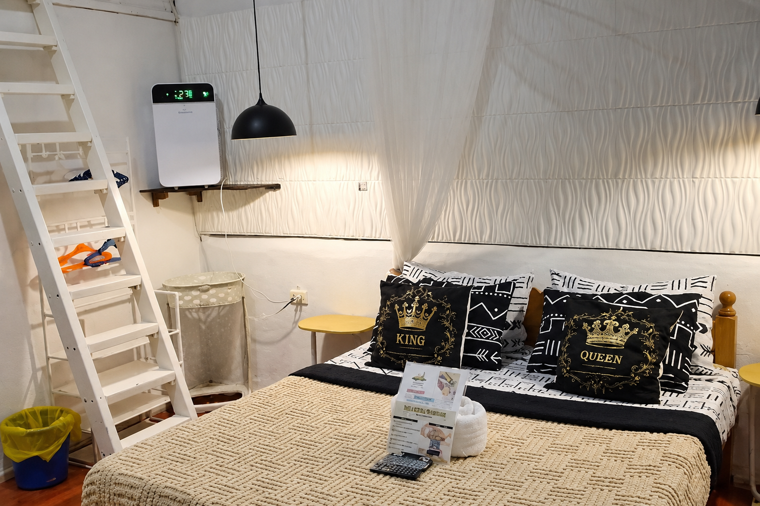 Guest room with a light canopy, bold patterned bedding and crowned cushions