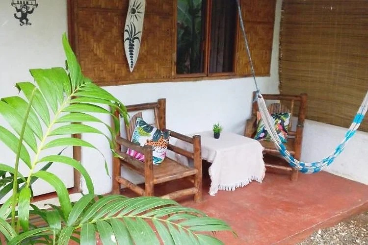 Outdoor seating, hammock and carved decorative detail at Two Crazy Monkeys